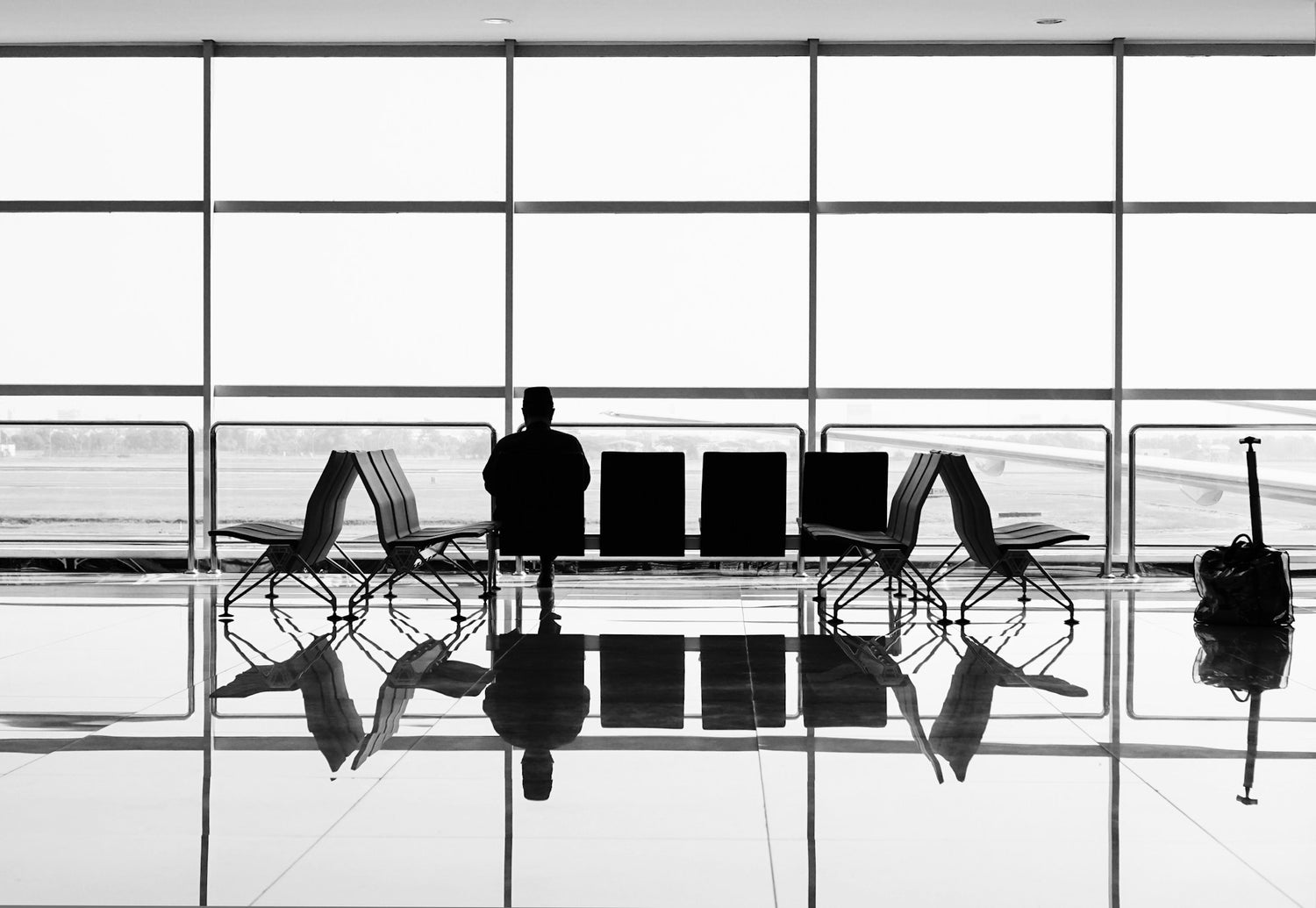 A frequent traveller, sitting in the terminal waiting for their flight.